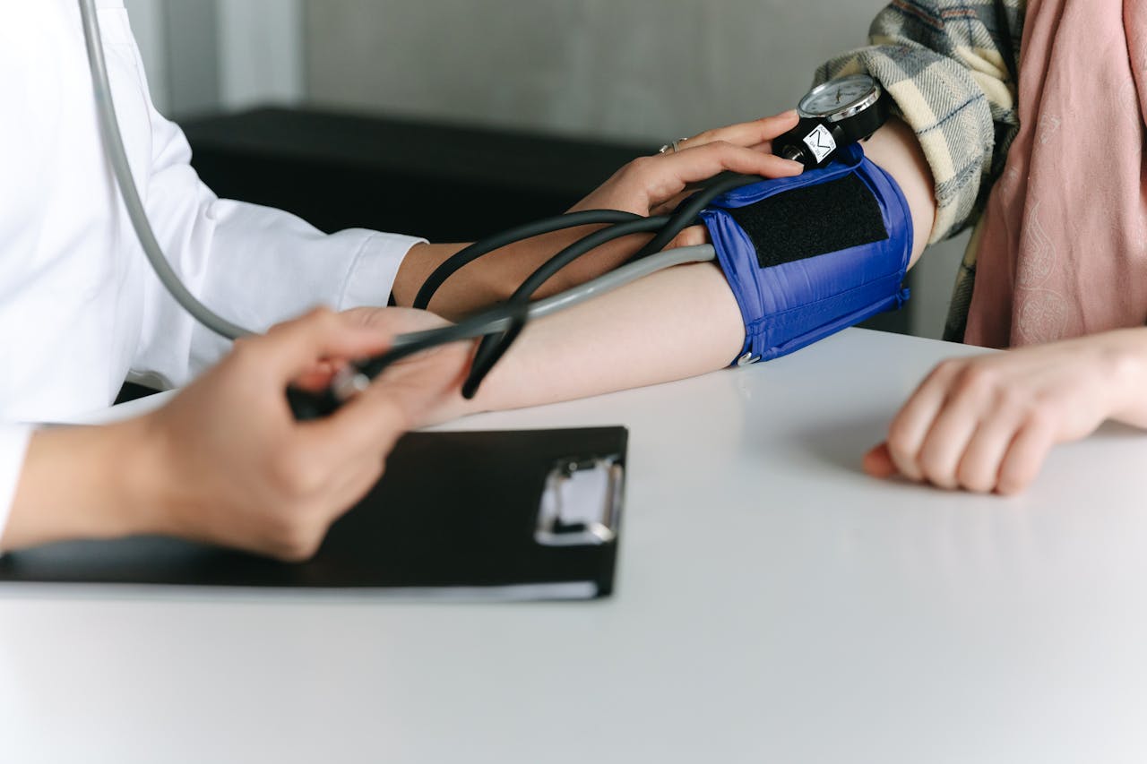 CardioClínico A healthcare worker uses a sphygmomanometer to check a patient